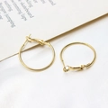 Close-up of gold-plated hoop earrings with glossy finish on elegant white silk fabric - 25mm / K Gold