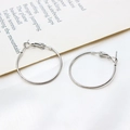 Macro view of silver circular hoop earrings with hinged closure on silk fabric - 30mm / White Gold