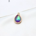 Macro detail of teardrop opal pendant with gold-plated frame on silk background - AB Aurora Purple