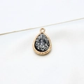 Macro view of water-drop resin pendant with gold plated edge and silver foil accents - Black Silver Foil Style