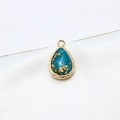 Macro detail of teardrop resin pendant with gold-plated textured frame and gold foil inserts - Blue Gold Foil Style