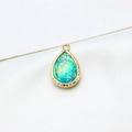 Macro view of water drop opal pendant with gold plated edge and textured rim detail - AB Aurora Aqua Blue