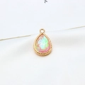 Macro detail of a gold-plated teardrop pendant with iridescent pink faux opal stone inlay - AB Iridescent Light Pink