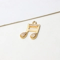 Macro shot of gold-plated music note pendant with sparkling zircon micro-inlay details - Sixteenth Note Style