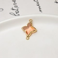 Detail of peach pink faceted glass star pendant with gold plated edges and double loops - Champagne