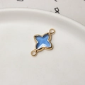 Macro shot of gold-plated four-pointed star pendant with blue resin and dual loops - Light Blue