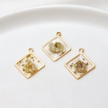 Detailed view of square gold-rimmed resin pendants with gold foil and dried flowers - Square / White