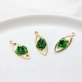 Macro detail of resin flower pendants with gold foil in gold plated frames for DIY jewelry - Marquise / Green