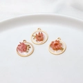 Macro detail of handmade resin floral pendants with pink dried flowers and gold leaf foil - Circle / Pink