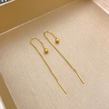Dettaglio di orecchini a catenella dorati con sfere lucide e sottili fili metallici - Fagiolo d'Oro Lucido / Oro