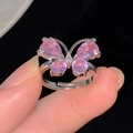 Detail of silver bow ring with pink zircon stones held against a black velvet background - Butterfly Shape Style (R332-56)