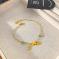 Macro detail of gold bear and moon charms with turquoise beads on a titanium chain - Bear Moon Green Bead Style (B340)