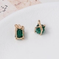 Macro view of gold gift box pendants with emerald crystals and dainty bow details - Green