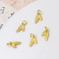 Detailed view of five golden bamboo leaf charms for DIY jewelry with matte finish - Double Leaf Style (02#7*12mm)