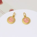 Macro shot of two round gold-plated charms with pink enamel Love heart centers - Pink Base Love Alphabet Round Style (LF3027)