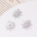 Macro view of silver starburst pendants with pavé-set zircons on white tray - 03#16*18 / Sun Silver Style