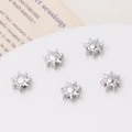 Dettaglio macro di 5 perline a forma di sole in argento lucido per orecchini fai-da-te - Distanziatore Sole Argento