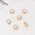 Macro-opname van 6 vergulde zirkoon hangerhouders voor DIY sieraden op witte houder - Goud