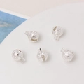 Detailed view of five hollow silver flower pattern bell charms for jewelry making - 8mm / Silver