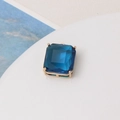 Macro shot of dark blue faceted crystal charm with a four-prong gold metal setting - Peacock Blue