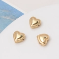 Macro shot of gold-plated heart beads with milgrain edges and lateral holes for DIY jewelry - 18K Gold