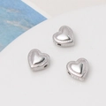 Macro shot of S925 sterling silver heart-shaped beads with beaded edge and mirror polish - White Gold