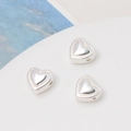 Close-up of three gold-plated heart beads with beaded borders for DIY jewelry making - Silver