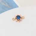 Macro shot of gold sun pendant with blue center stone and zircon accents for jewelry DIY - Dark Blue
