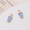 Close-up of light blue teardrop crystal pendant with gold setting and small zircon accent - Jelly Blue