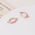 Detailopname van roze zeshoekige glazen hangers met gouden frames voor DIY-sieraden - Roze