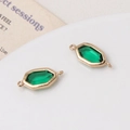 Macro-opname van smaragdgroene glazen hangers met gouden frames voor DIY-sieraden - Retro Groen