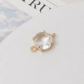 Macro view of a faceted clear zircon charm with dual gold-tone connecting rings for DIY jewelry - White