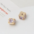 Macro shot of gold-plated cubic charms with purple zircon stones for DIY jewelry making - 8mm / Gold/Light Purple