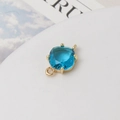 Vue macro détaillée d'un pendentif en cristal bleu mer carré avec serti griffes doré pour bijoux - Bleu lac