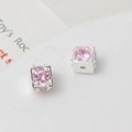Macro detail of square silver spacer beads with pink zircon inlay for jewelry making - 6mm / Silver/Pink