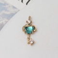 Detail eines kreativen Gold-Schlüsselohrrings mit blauem Planeten-Anhänger und Zirkonia - Aqua