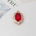 Makro-Detail des ovalen roten Edelsteinanhängers mit Zirkonia-Halo und Goldbeschichtung - Rot