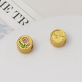Macro shot of gold tulip and embossed flower charms for DIY jewelry making - Purple