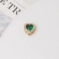 Macro view of heart-shaped green zircon charm with gold plating and halo stones - 10mm / Gold Plated Green