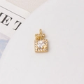 Macro detail of gold perfume bottle pendant with zircon pavé and butterfly motifs - White Perfume Bottle