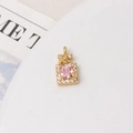 Detailed close-up of a golden perfume bottle pendant with pink gem and butterfly - Pink Perfume Bottle
