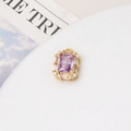 Macro detail of a gold plated rectangular pendant with purple stone and zircon border - Light Purple