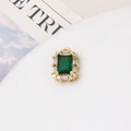 Detailed macro view of an emerald green gemstone pendant with micro-paved cubic zirconia - Green