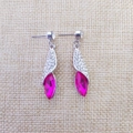 Vue macro de boucles d'oreilles argentées avec cristaux marquises roses et détails pavés - Argent & Rouge Pourpre