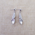 Détail de boucles d'oreilles argentées avec strass torsadés et cristal goutte d'eau - Argent
