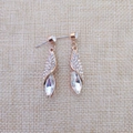 Détail de boucles d'oreilles dorées en forme de feuille avec strass et cristal marquise - Or Blanc