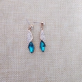 Detailansicht eleganter Roségold-Ohrhänger mit blauem Markasit-Kristall und Pavé-Strasssteinen - Gold Pfauenblau