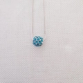 Dettaglio ravvicinato di una collana a catena a serpente d'argento con ciondolo a sfera blu - Collana / blu mare