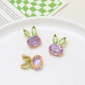 Detailed macro view of three purple crystal rabbit pendants with green gem ears on a plate - Rabbit Style / Purple