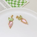 Close-up of cute pink and green crystal carrot pendants with gold metal frames for DIY - Carrot Style / Pink